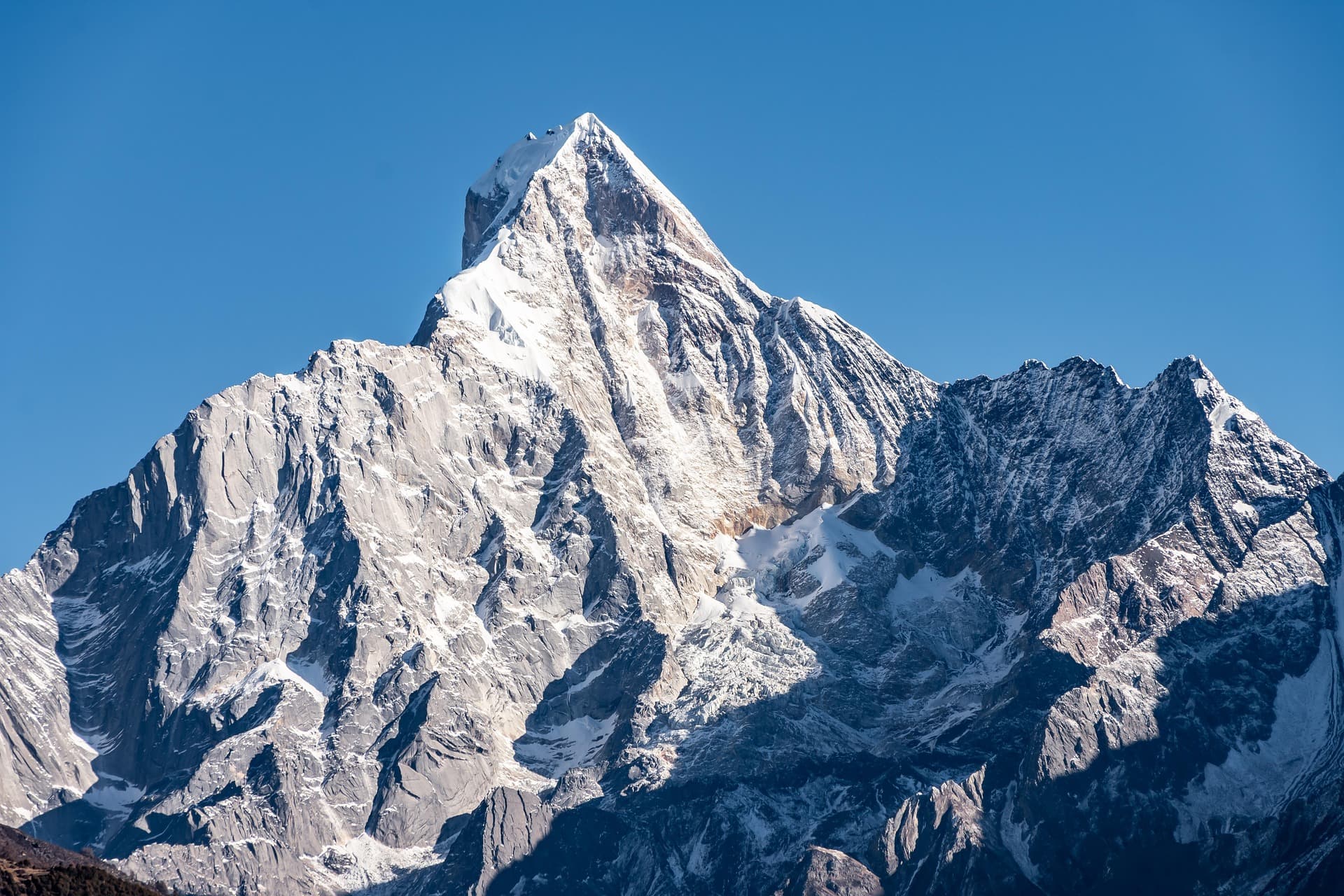 Snow-covered Siguniang Mountain peak under clear blue sky, symbolizing the daunting querying, submission, and publishing journey