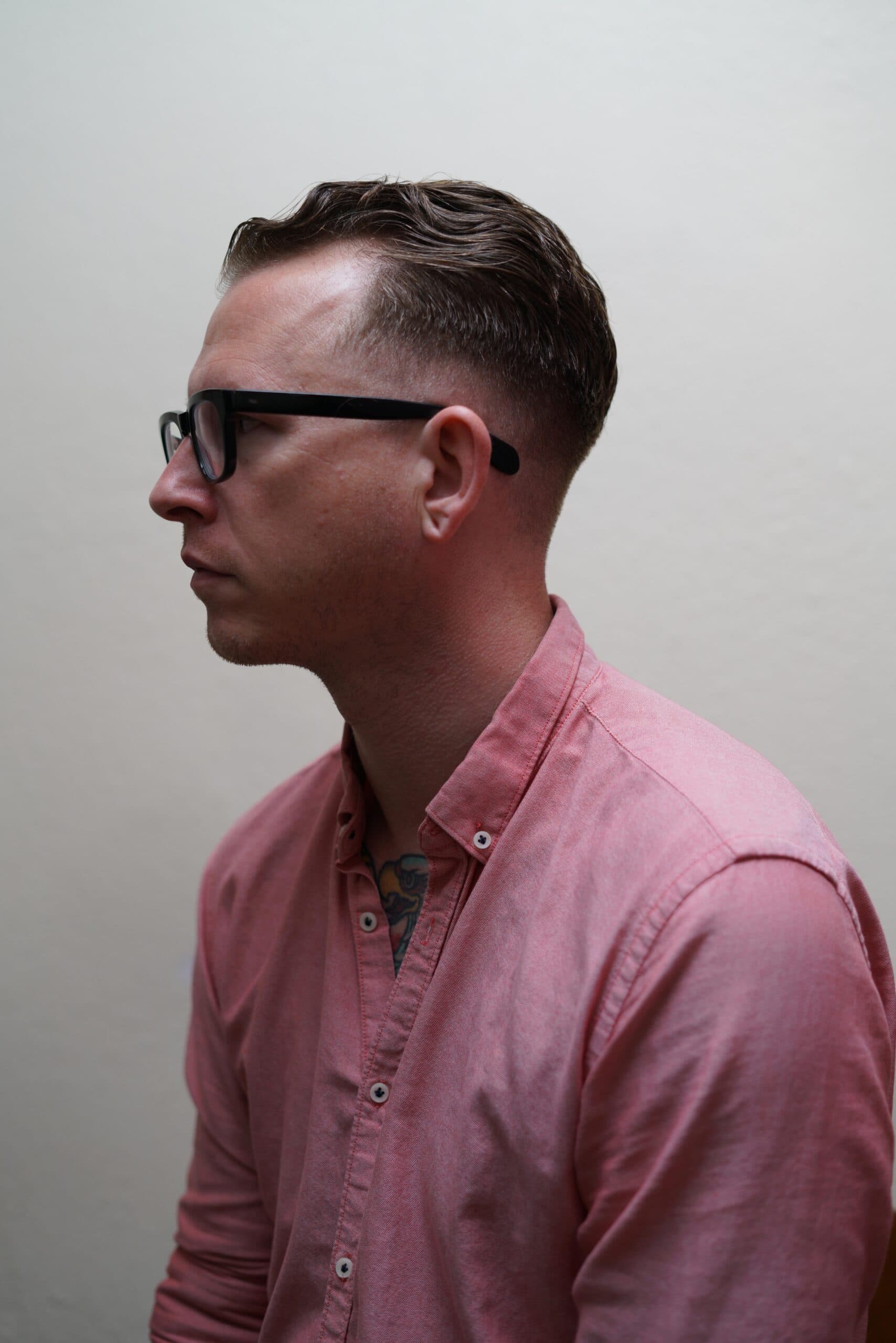 Side profile portrait of a man in a pink shirt and glasses, representing the real human behind Write Query Hook